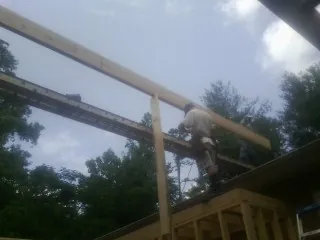 Carpenter setting a ridge beam over a new addition frame — Ice Dam Removal by Roofing Brothers in Mantua