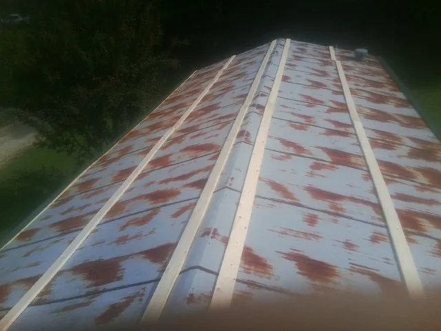Rusted metal roof panels with new wood purlins before replacement — Storm Damage Roof Repair in Mantua by Roofing Brothers