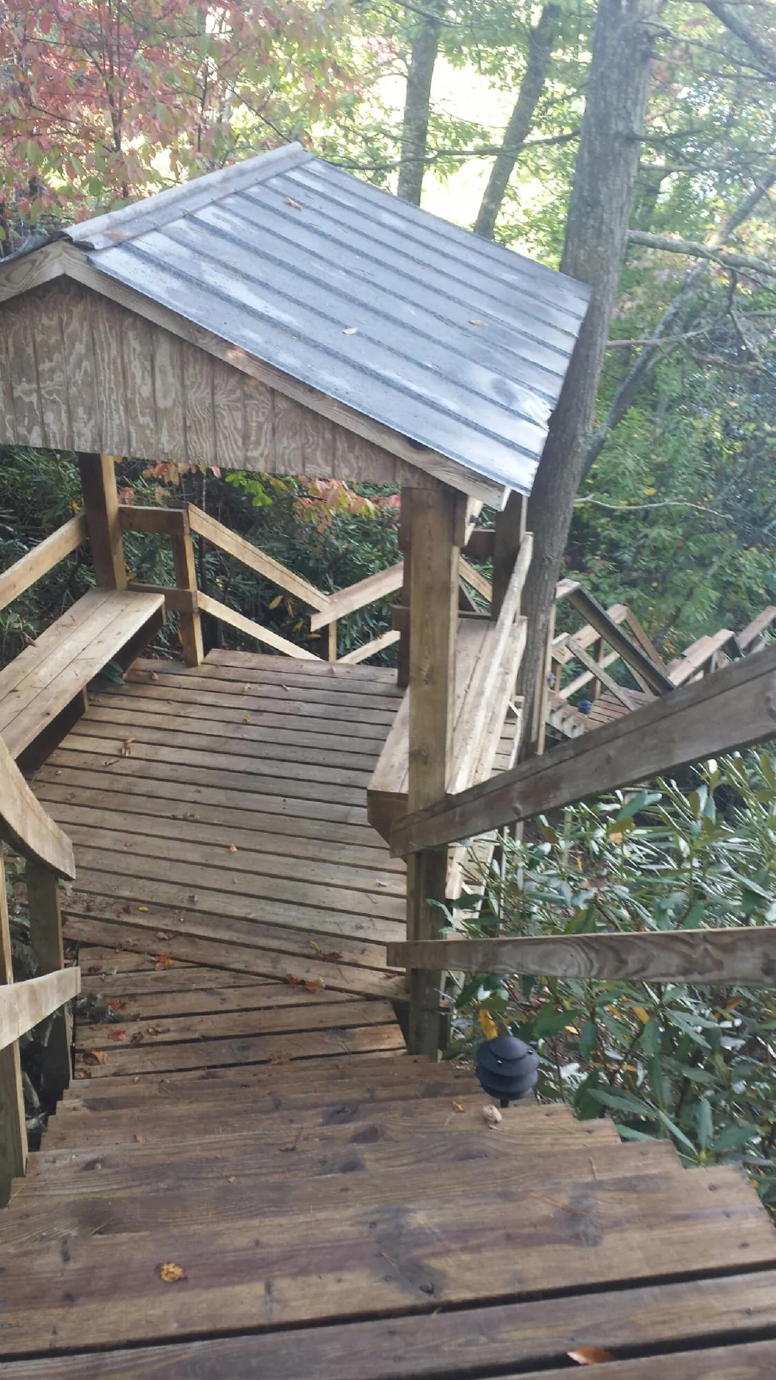 Metal roofed shelter over wooden steps on a wooded walkway — Skylight Repair & Installation work by our crew in Mantua