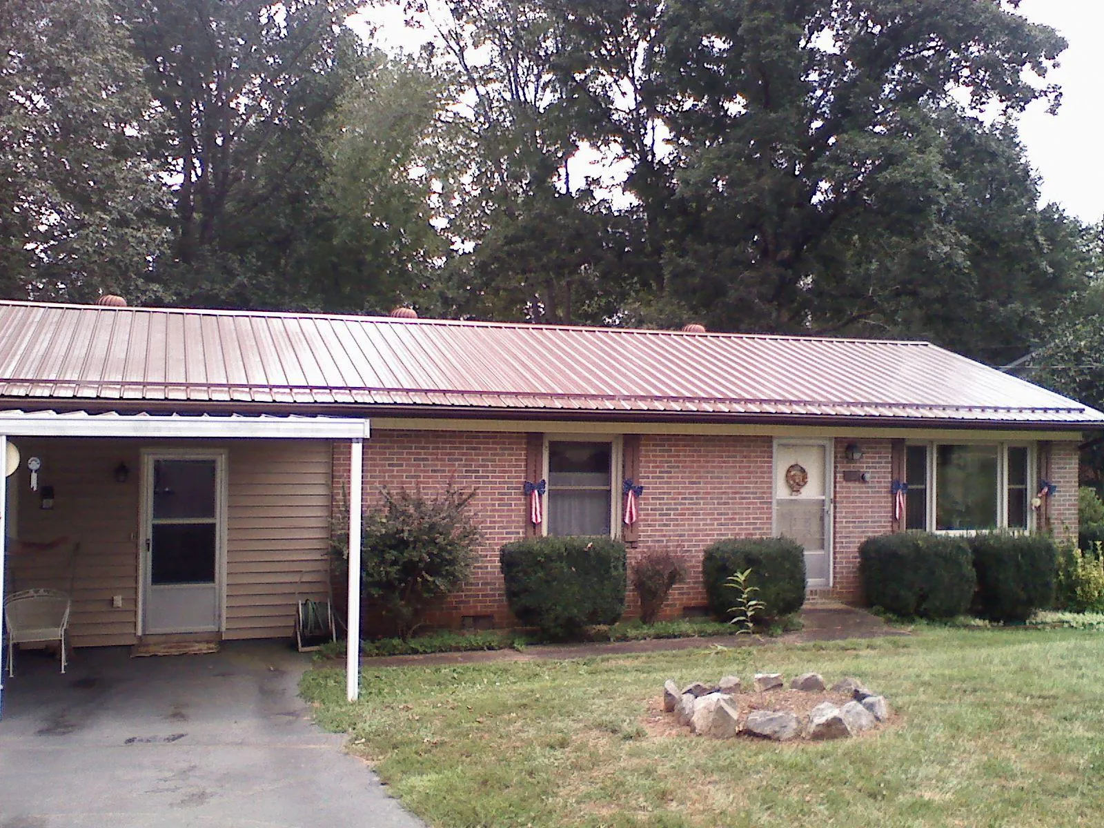 Bronze metal roof and carport on a brick ranch home — Roof Repair work by our crew in Mantua